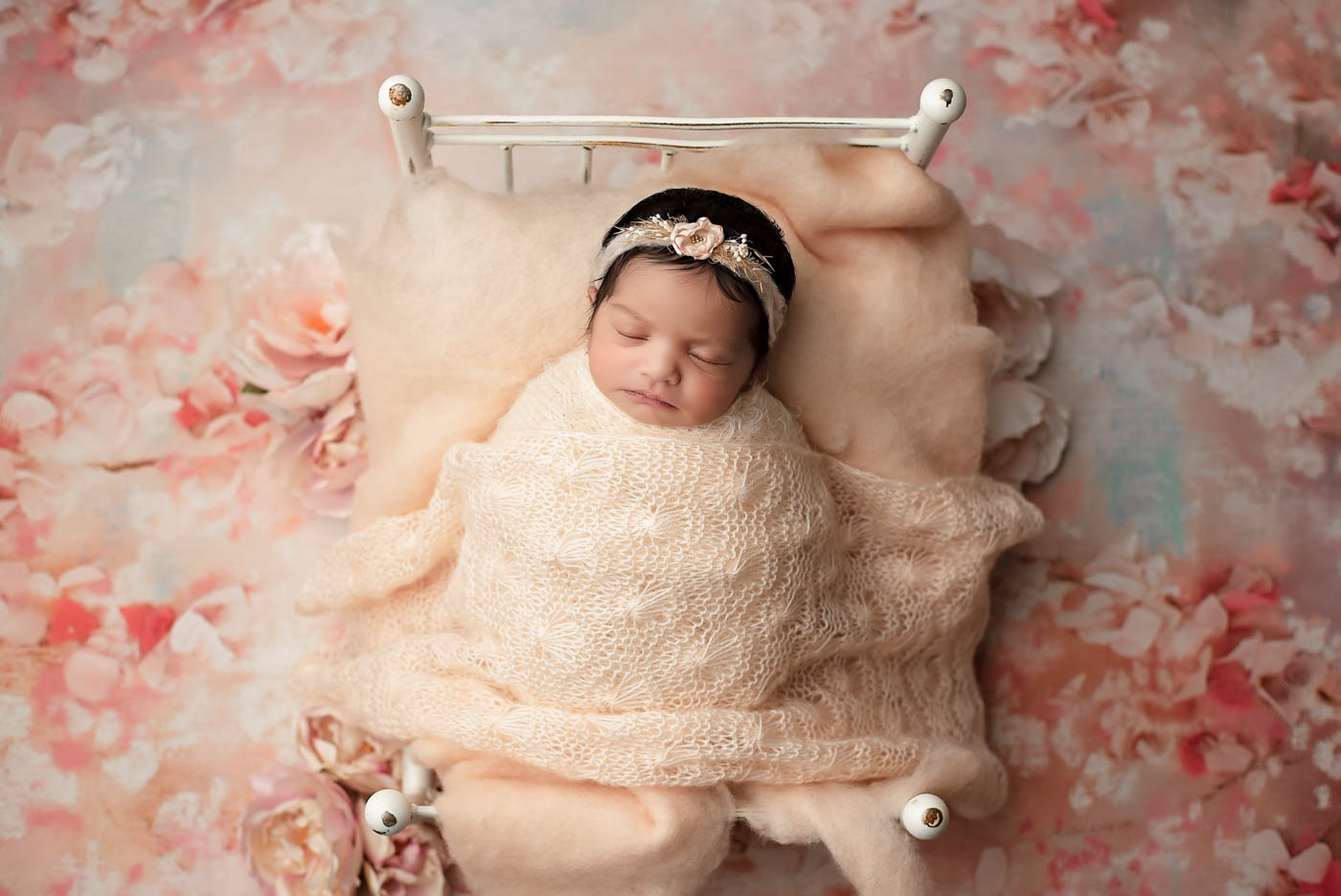 Newborn Baby Sleeping In A Miniature Bed With Soft Neutral Newborn Photography Props