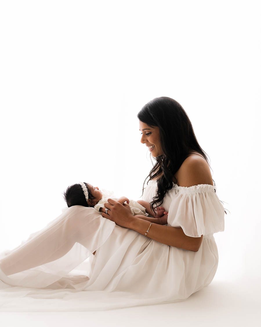 Mother Holding Newborn During A Softly Styled Neutral Newborn Session