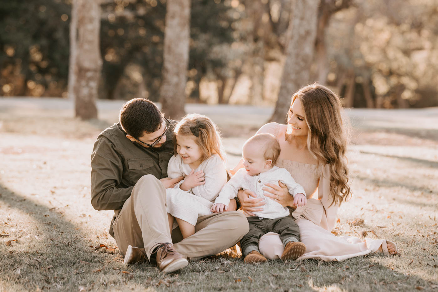 Family Wearing Soft Neutral Colors During A Relaxed Outdoor Portrait Session