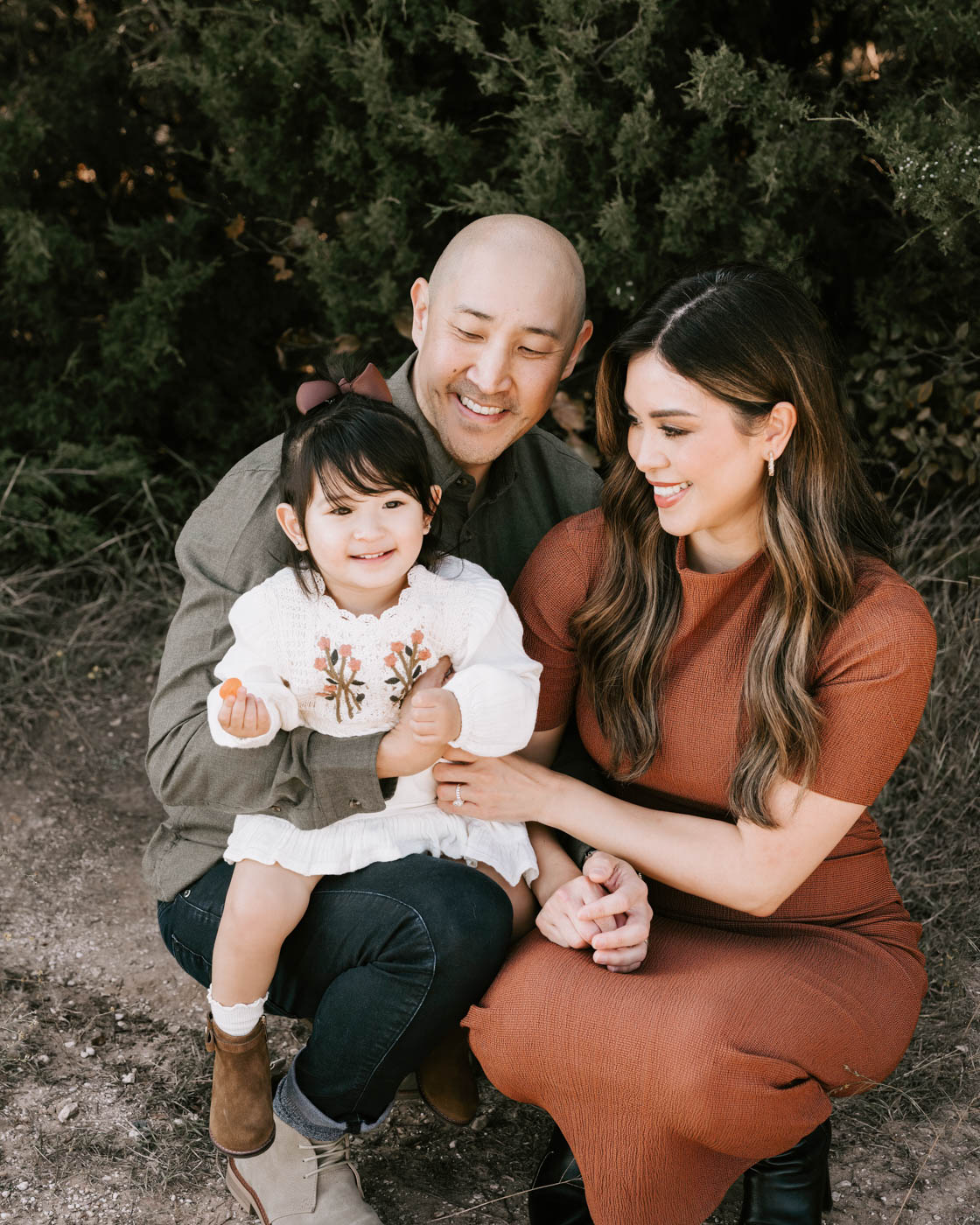 Parents And Child Wearing Coordinated Earth-Tone Outfits For Family Photos