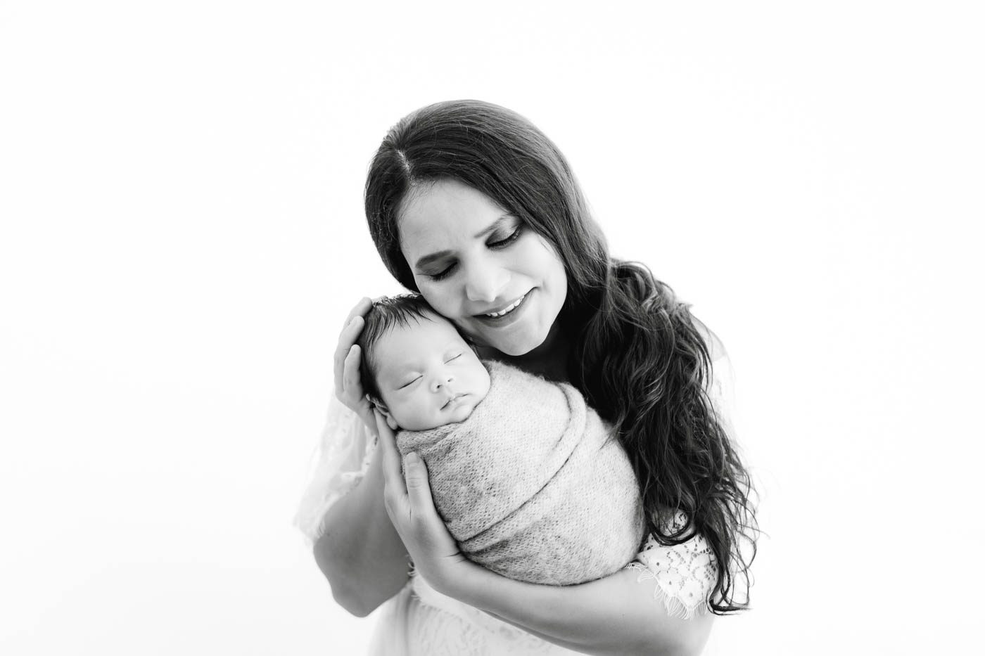 Mother Holding Her Newborn Baby During A Studio Newborn Photography Session