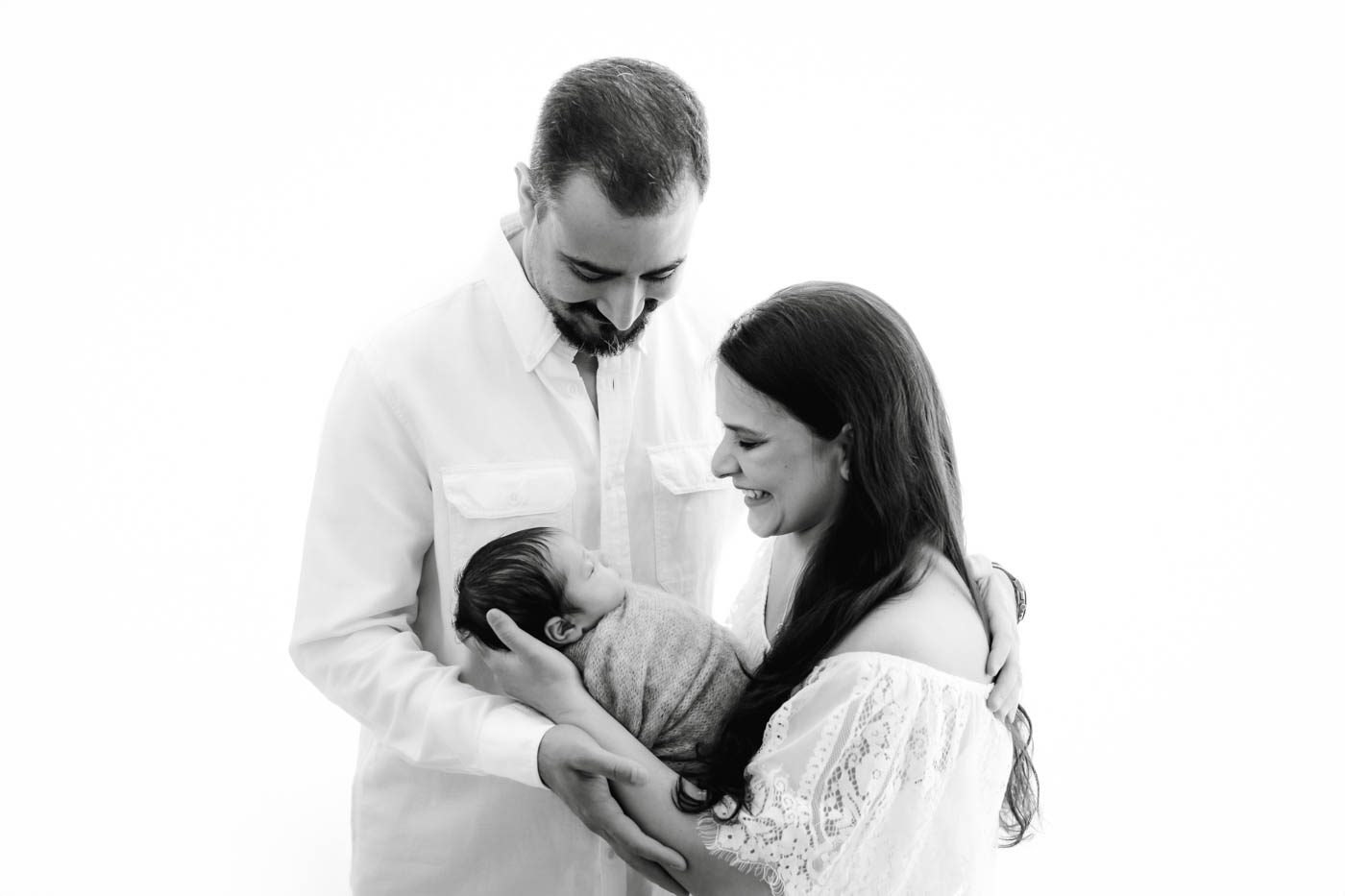 Parents Holding Their Newborn Baby During A Professional Newborn Photography Session