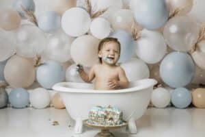 A Baby In A Bathtub With Cake And Balloons For Cake Smash Photography