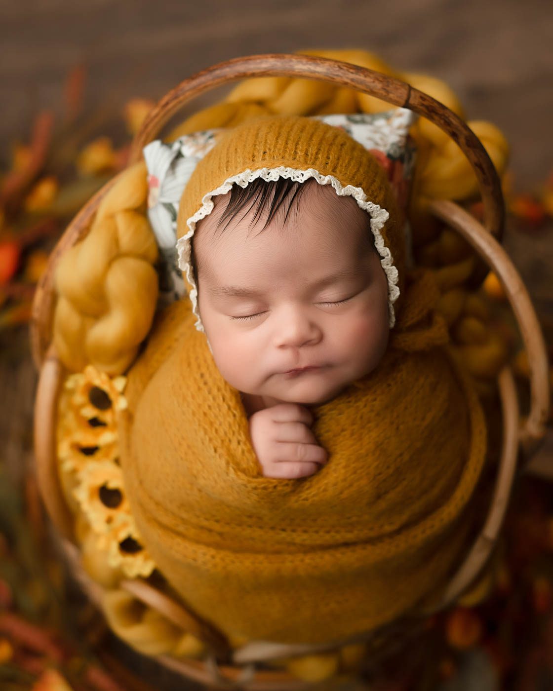Sleeping Newborn Baby Wrapped In Warm Autumn Tones During A Newborn Photoshoot In Dallas