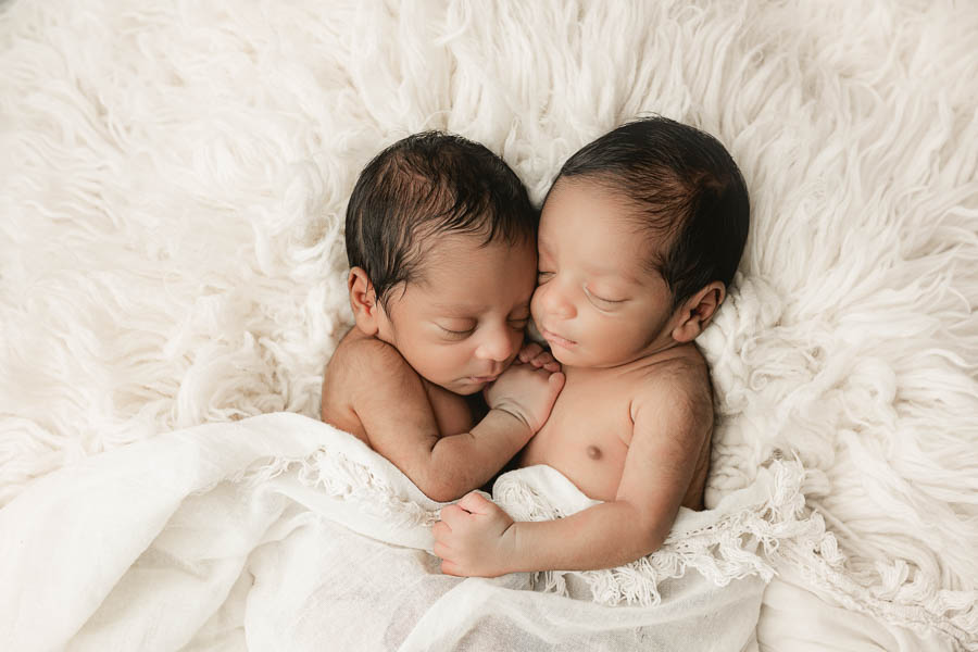 Twin Babies Wrapped In Soft Neutral Fabrics During A Peaceful Studio Baby Session.
