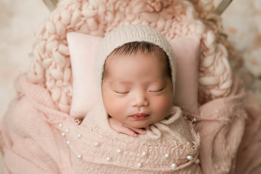 Close-Up Newborn Portrait Featuring Soft Blush Tones And Peaceful Baby Posing During A Newborn Photography Session.
