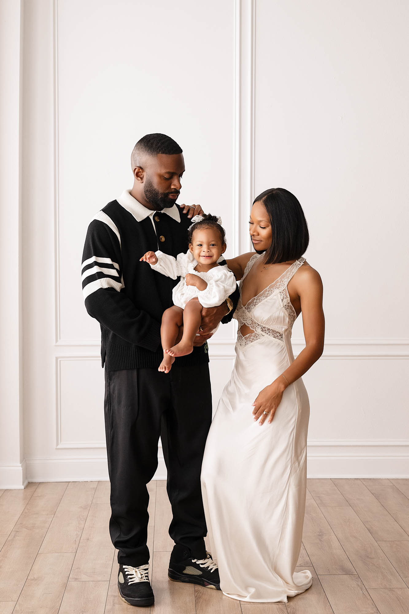 Stylish parents holding their baby girl during a Dallas family photography studio session