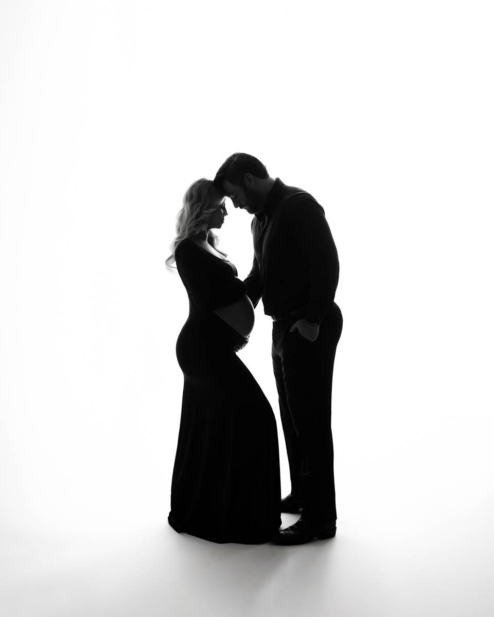 Black and white silhouette pregnancy portrait captured by a pregnancy photographer, Lily Hayes Photography featuring expecting parents sharing an intimate moment