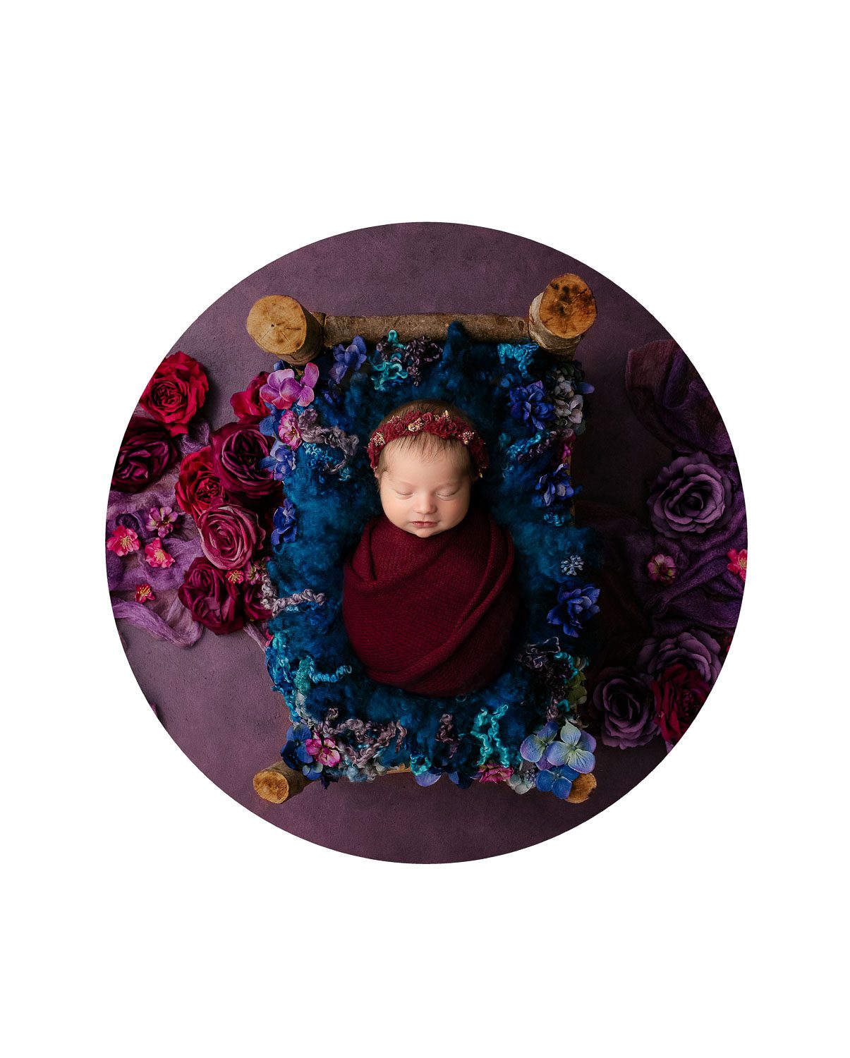 Fine art newborn portrait featuring rich jewel tones and floral styling photographed in Dallas studio
