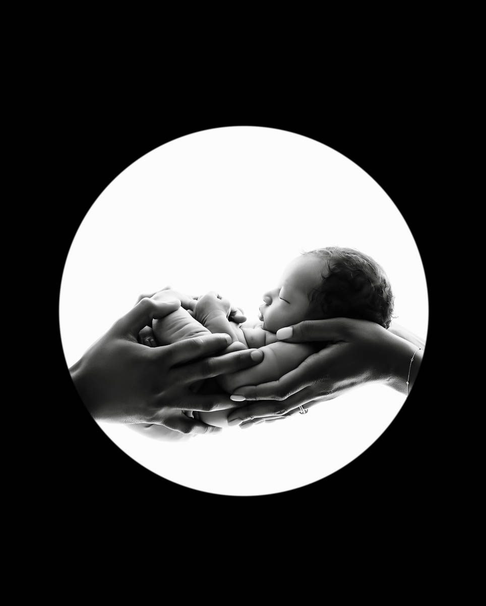 Black and white newborn portrait of a baby held in parents hands captured by Dallas maternity, newborn and family photographer Lily Hayes