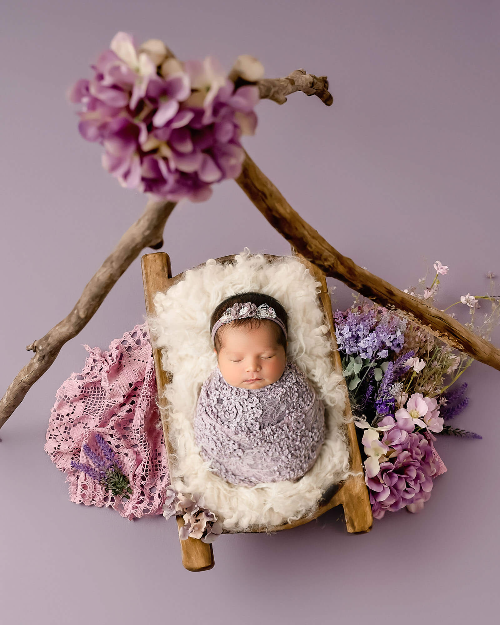 Newborn photography session in Dallas studio with baby in floral setup by Lily Hayes Photography