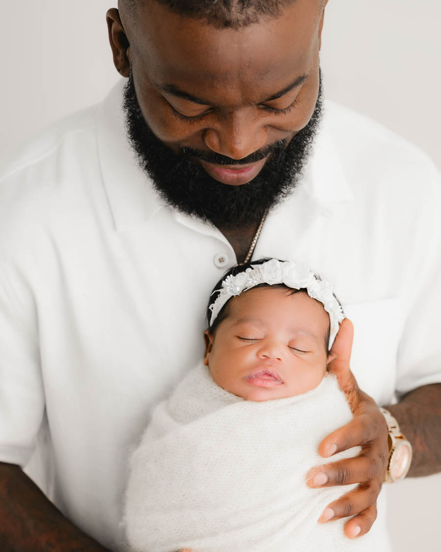 Father Holding His Sleeping Newborn Baby During The First Few Weeks After Birth