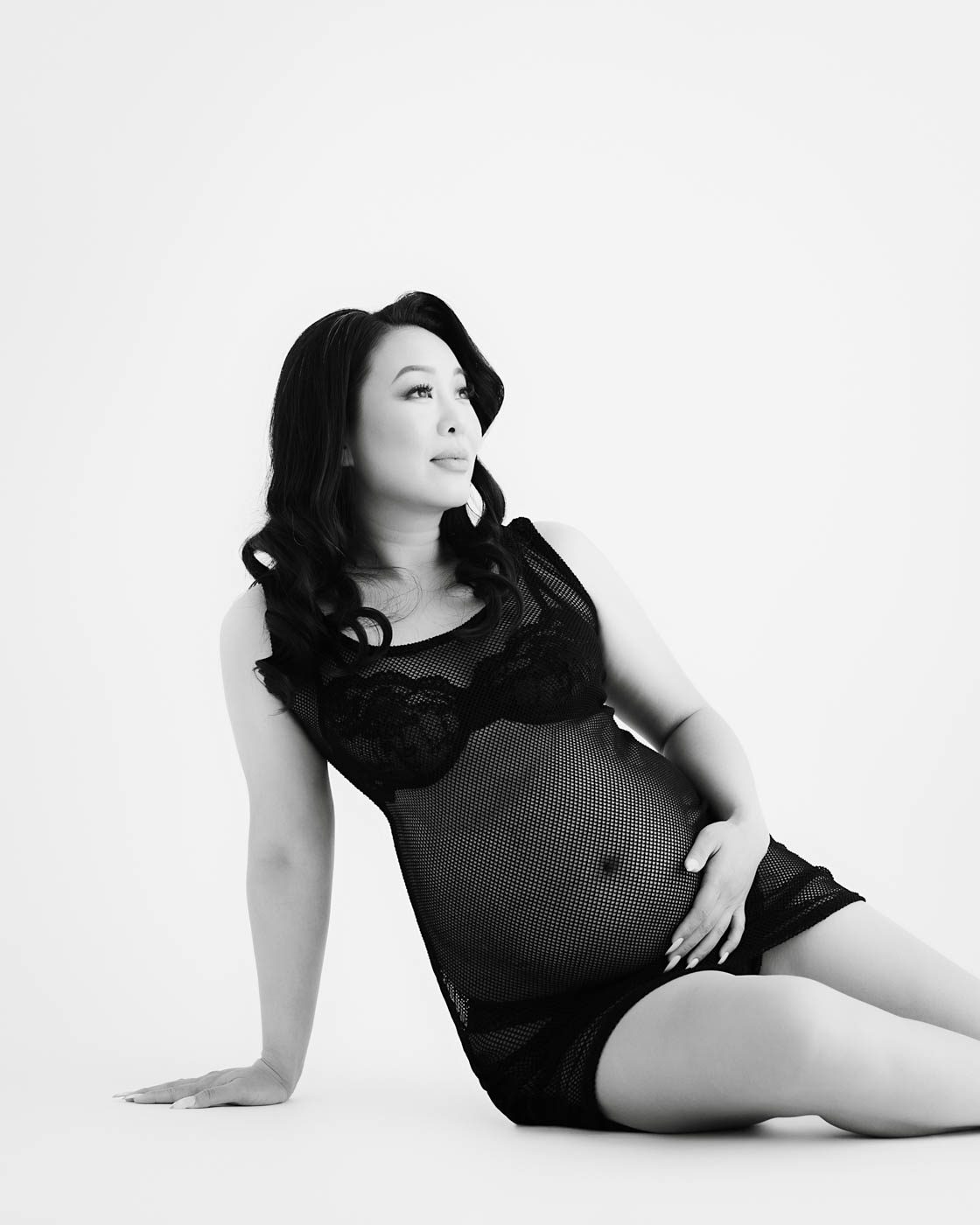 Expecting Mother Posing In Elegant Black Dress During Studio Maternity Session In Dallas