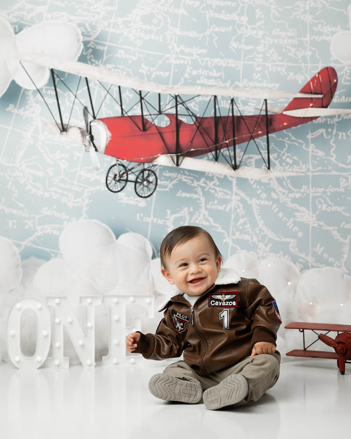 Smiling One-Year-Old During A Dallas Baby Photoshoot With A Vintage Aviation-Inspired Theme