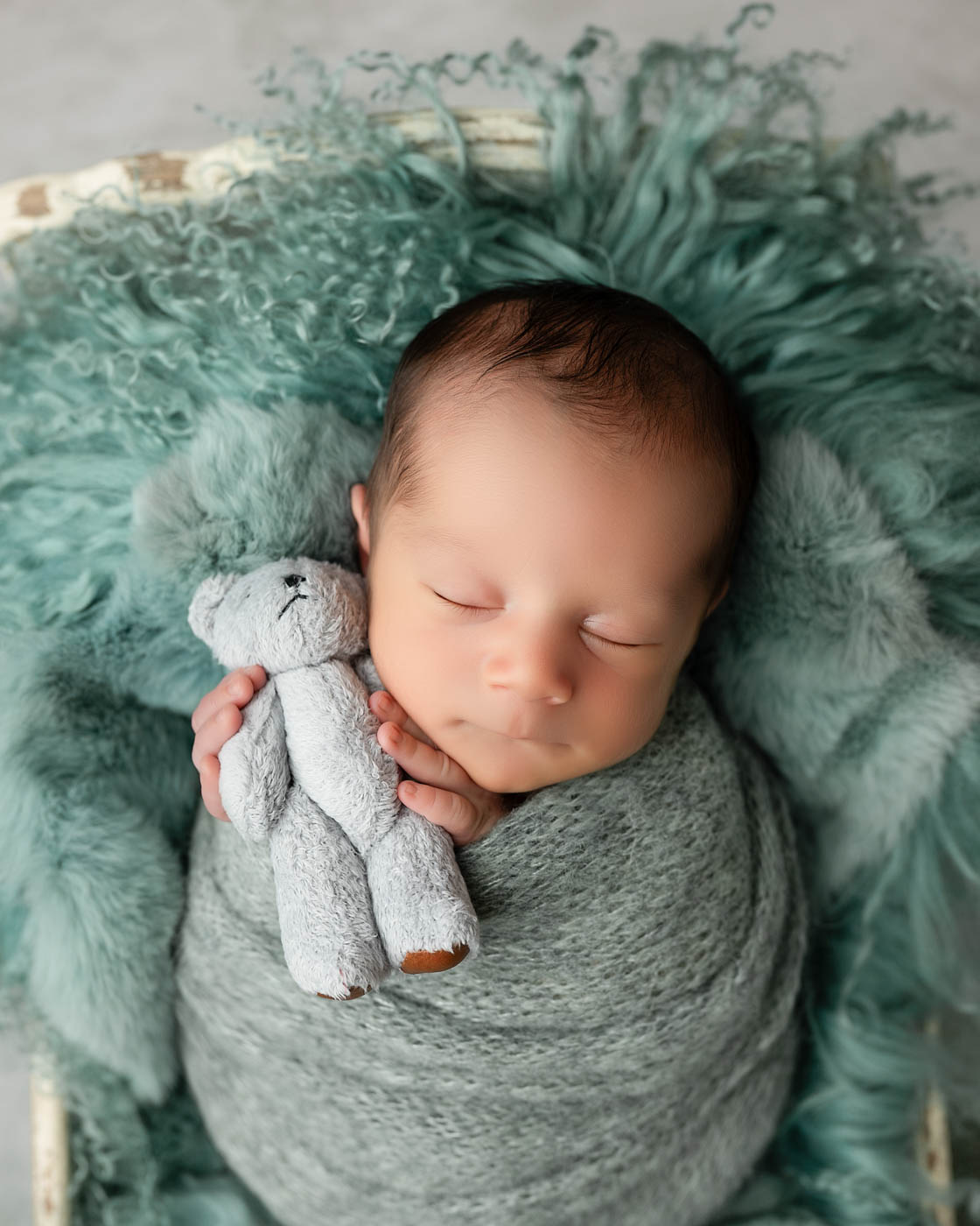 Close-Up Newborn Baby Portrait In Dallas Featuring A Sleeping Baby Holding A Soft Teddy Bear.