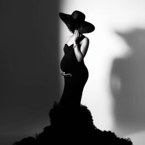 Black and white fine art maternity portrait of an expectant mother in a couture gown during a Dallas studio maternity photography session, featured with a five-star client review.