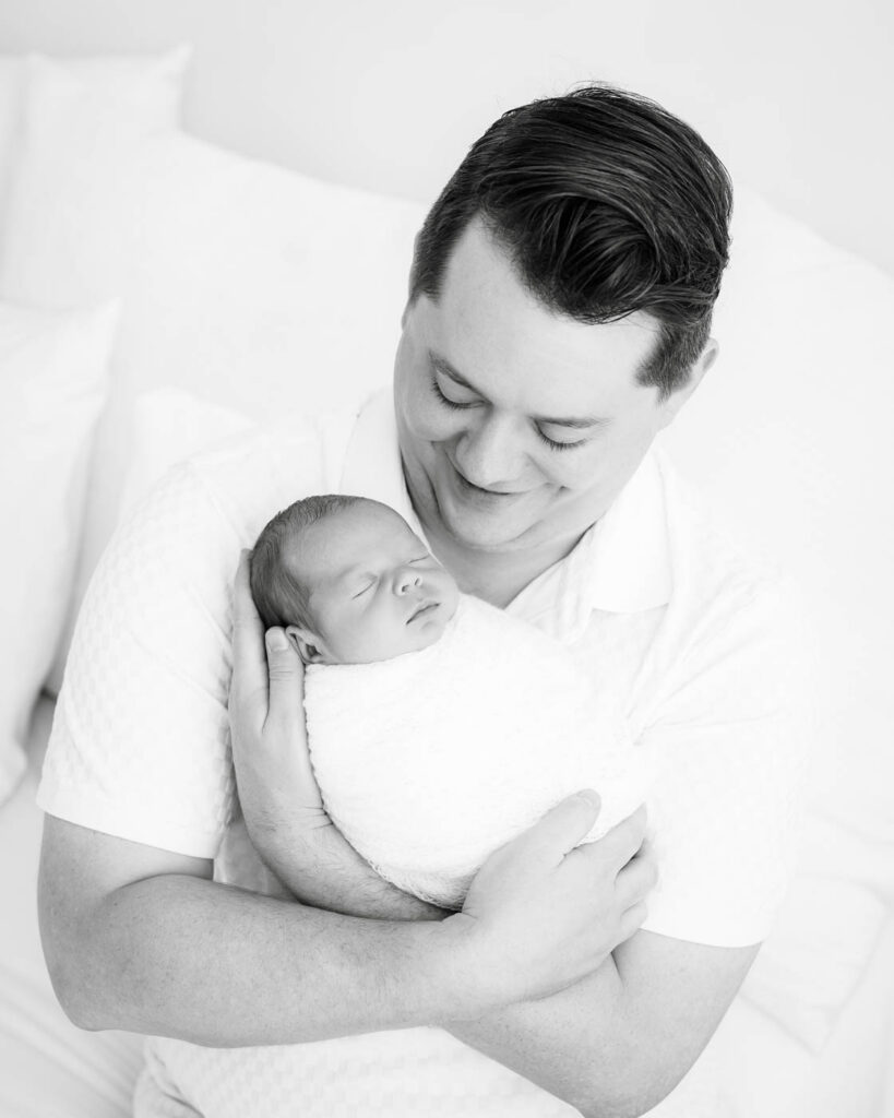 Dallas Newborn Photography Portrait Of A Father Holding His Sleeping Newborn Baby
