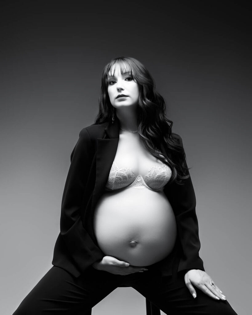 Pregnancy Photographer Dallas Portrait Of An Expectant Mother Seated In A Black Blazer And Lace Lingerie