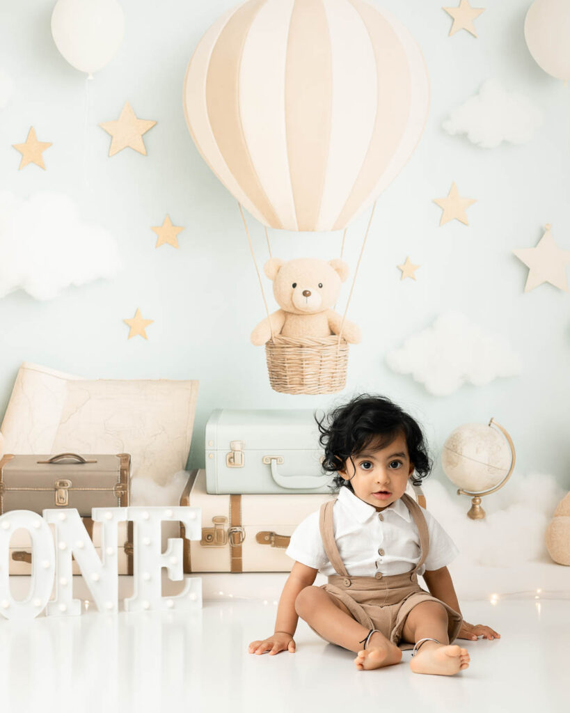 What Happens During A Dallas Cake Smash Session? From Portraits To Splash Bath 2 One-Year-Old Sitting On A Soft Blue Birthday Set During Portraits With A Cake Smash Photographer In Dallas