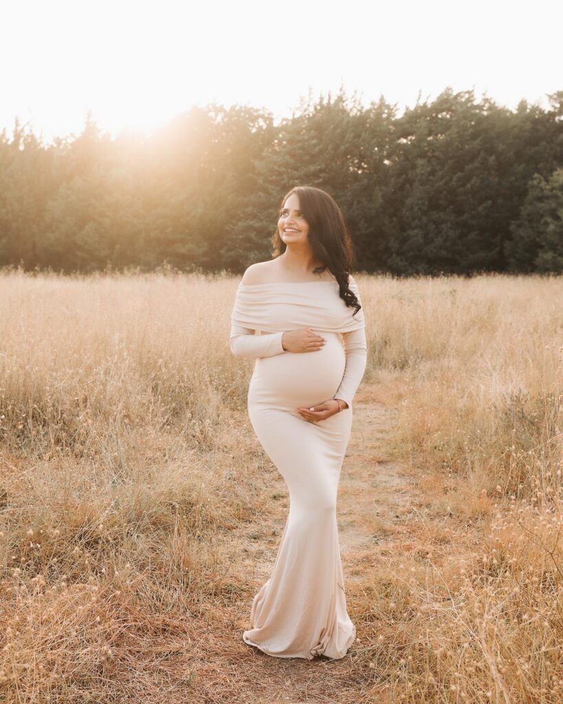 Dallas Maternity Photographer Captures Expecting Mother In Fitted Neutral Gown During An Outdoor Maternity Session.
