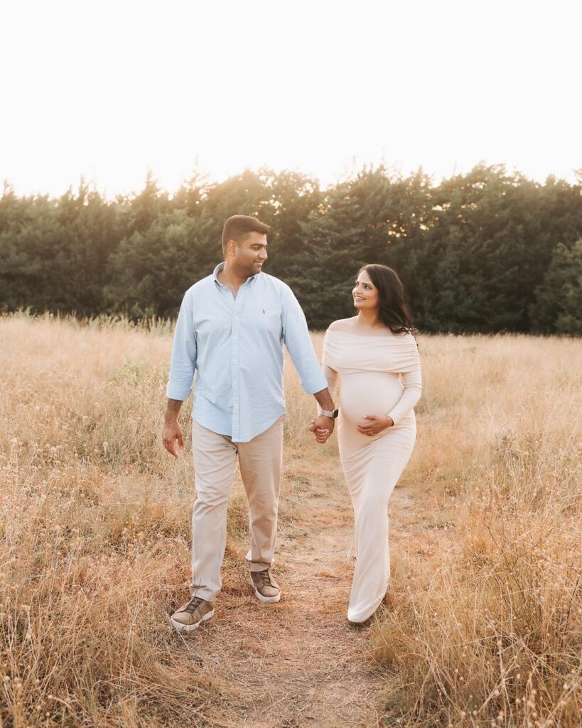 Dallas Pregnancy Photographer Captures Expecting Couple Walking Together During An Outdoor Maternity Photography Session.