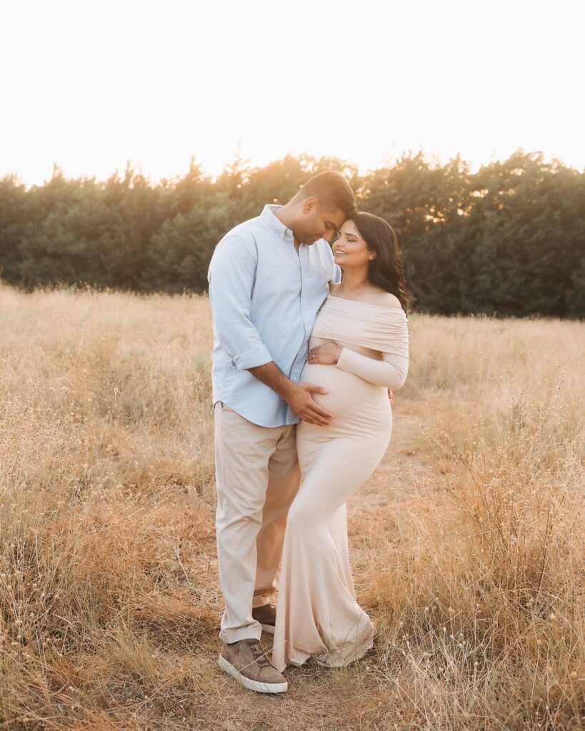 Luxury Maternity Photographer In Dallas Poses Expecting Couple Together For A Full Length Outdoor Maternity Portrait.