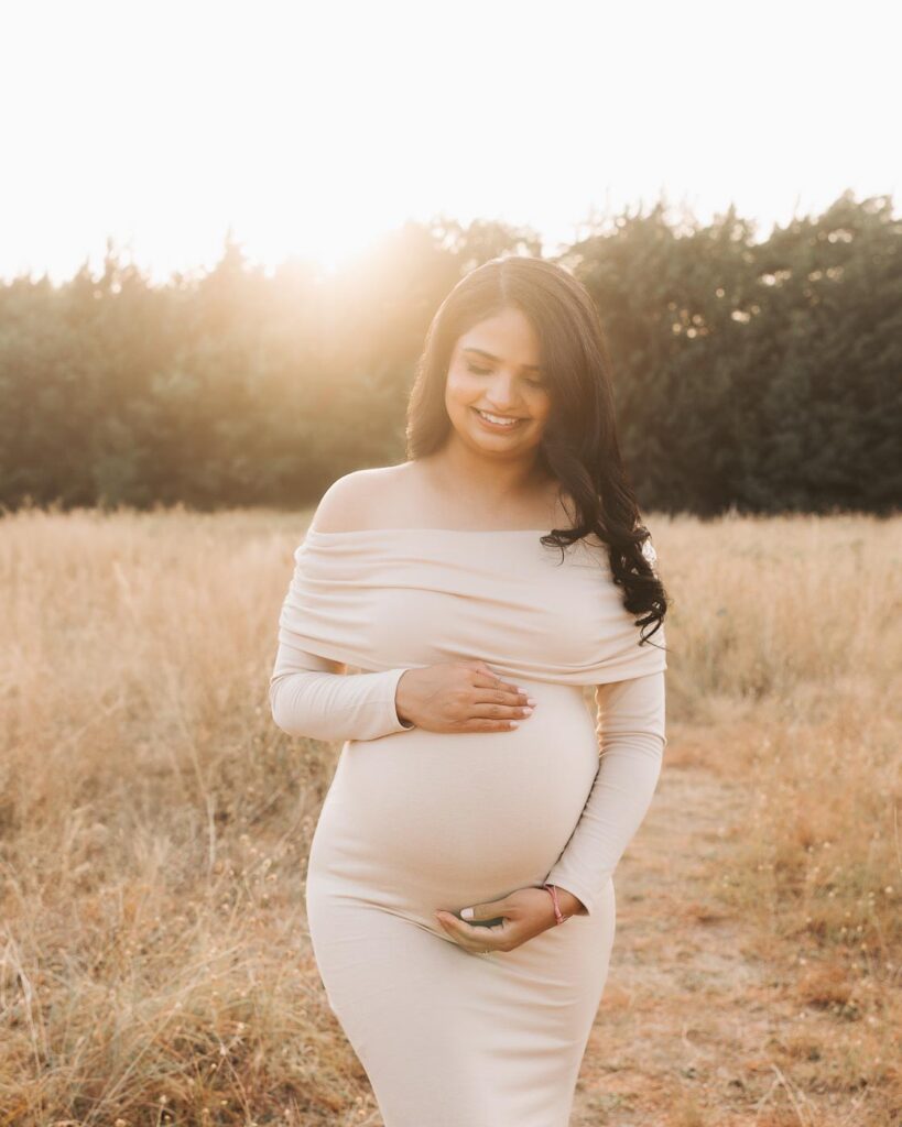 Outdoor Maternity Photography In Dallas Featuring Expecting Mother In An Off Shoulder Neutral Maternity Dress.