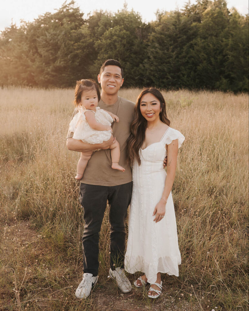 What If My Child Won’t Cooperate During Family Photos? 6 Family Photographer In Dallas Photographs Parents Standing Outdoors With Their Toddler During An Evening Family Session.