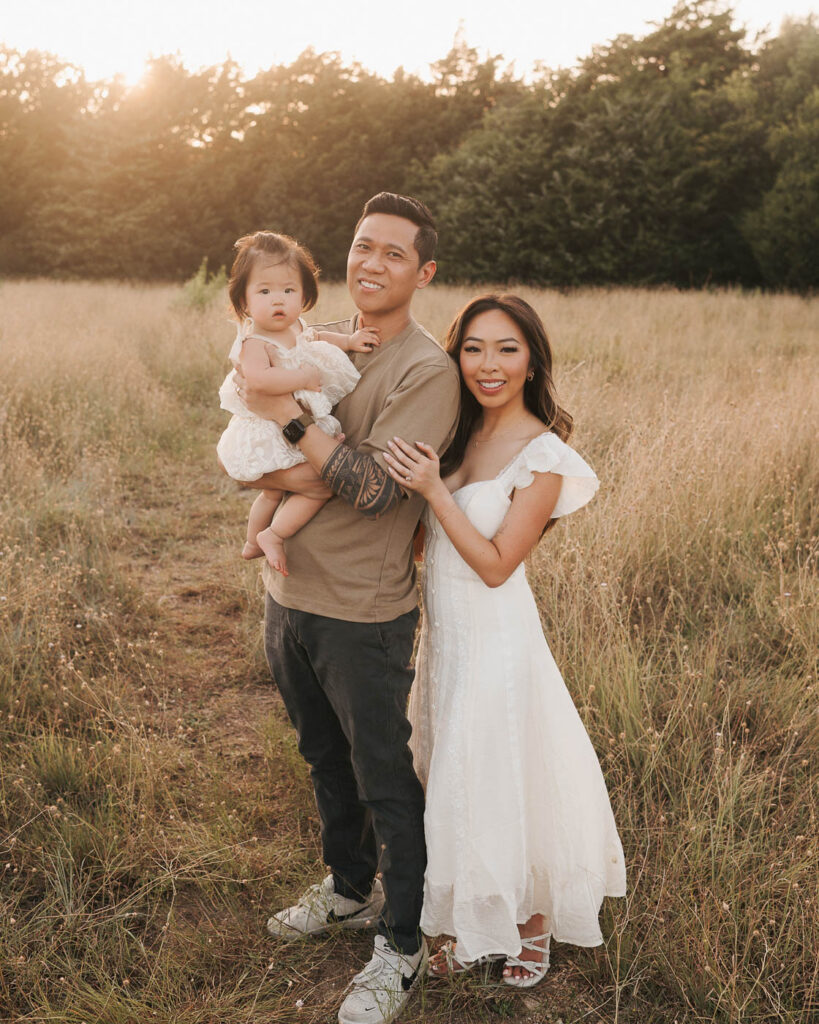 What If My Child Won’t Cooperate During Family Photos? 3 Family Photography In Dallas Featuring Parents And Their Toddler Together In An Outdoor Field At Sunset.