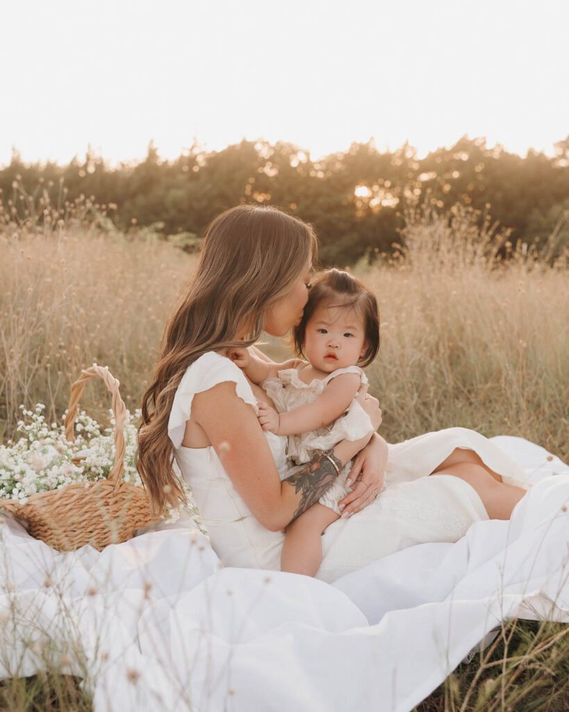 What If My Child Won’t Cooperate During Family Photos? 2 Mother Cuddles Her Toddler On A Picnic Blanket During Natural Family Photography In Dallas.