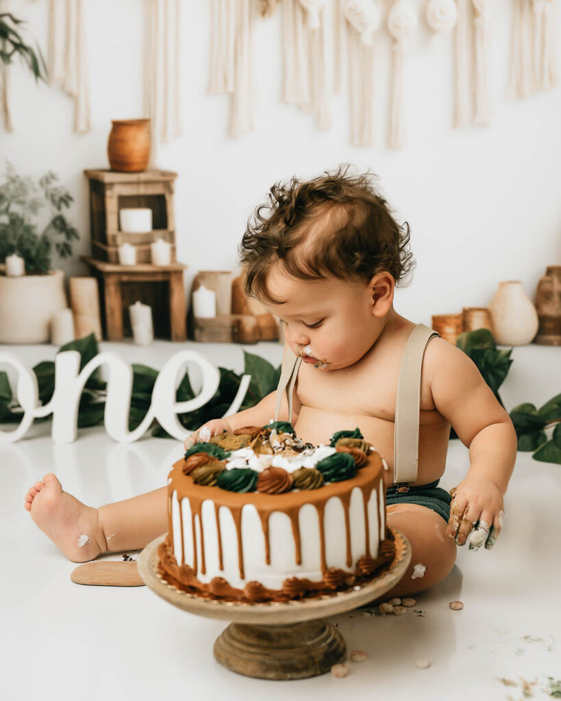 Baby Enjoying Cake During A Neutral Boho Cake Smash Session In Dallas