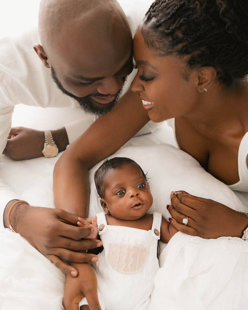 Parents Lying Close With Their Newborn During A Newborn Family Photography Session In Dallas