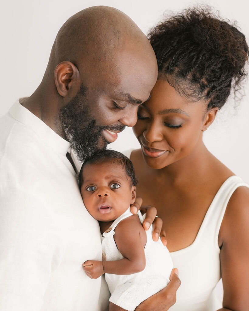 Parents Holding Their Baby Close During A Newborn Photography Session In Dallas