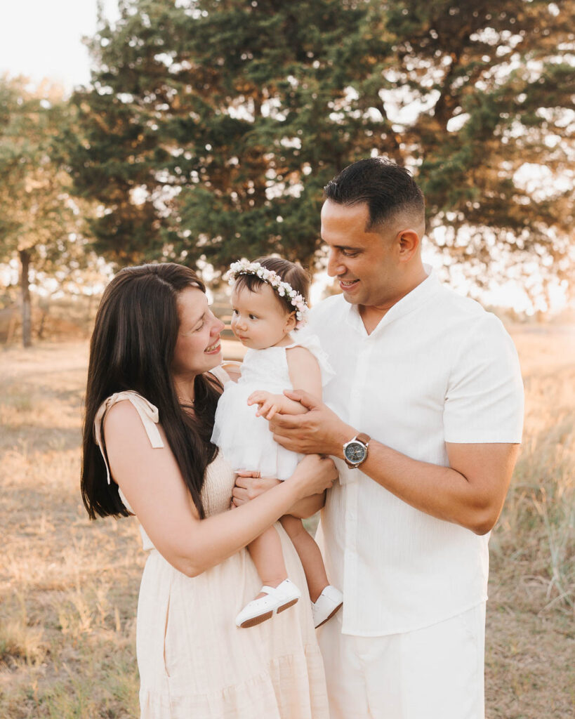 How A Dallas Family Photographer Works With Young Kids Who Don’t Want To Sit Still 5 Mom And Dad Holding Their Toddler During A Dallas Family Photo Session.