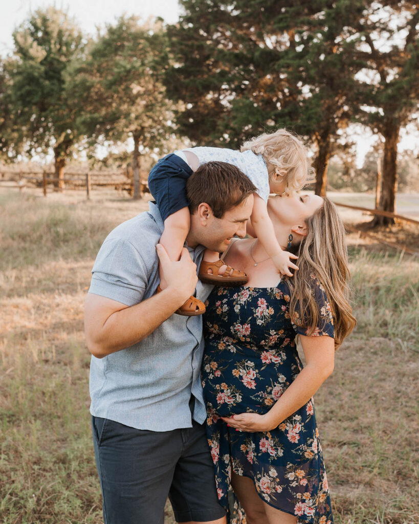 Maternity Photos With A Toddler: What Actually Works 7 Parents Interacting With Their Toddler During An Outdoor Maternity Session In Dallas.