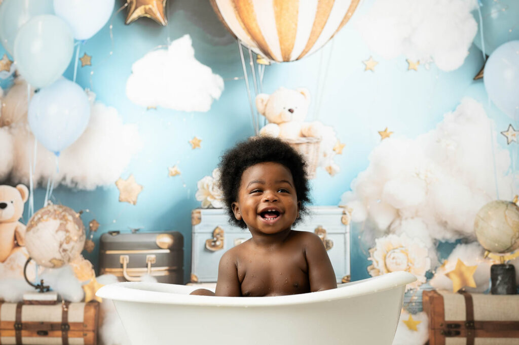 Smiling Baby Enjoying A Splash Bath After Cake Smash Photography In Dallas.
