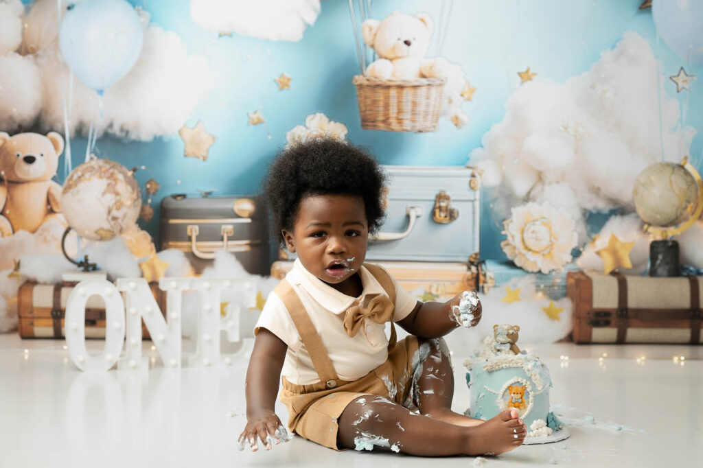 Active Baby Moving Near The Cake During A Dallas First Birthday Cake Smash Session.