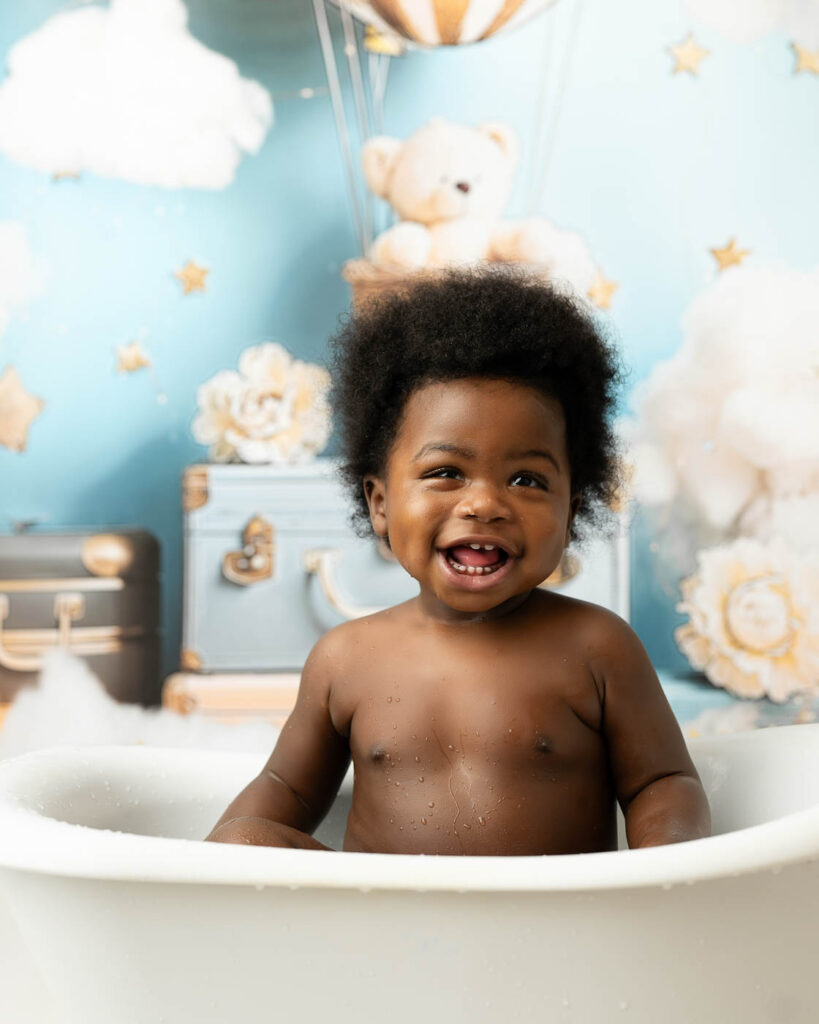 Smiling One-Year-Old Sitting In A Tub After An Active Dallas Cake Smash Session.