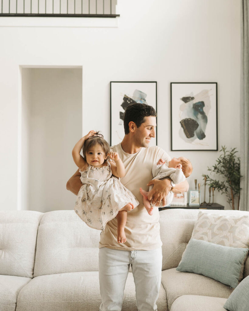 Father Holding His Newborn Baby Boy And Toddler Daughter During A Dallas Studio Lifestyle Newborn Photography Session
