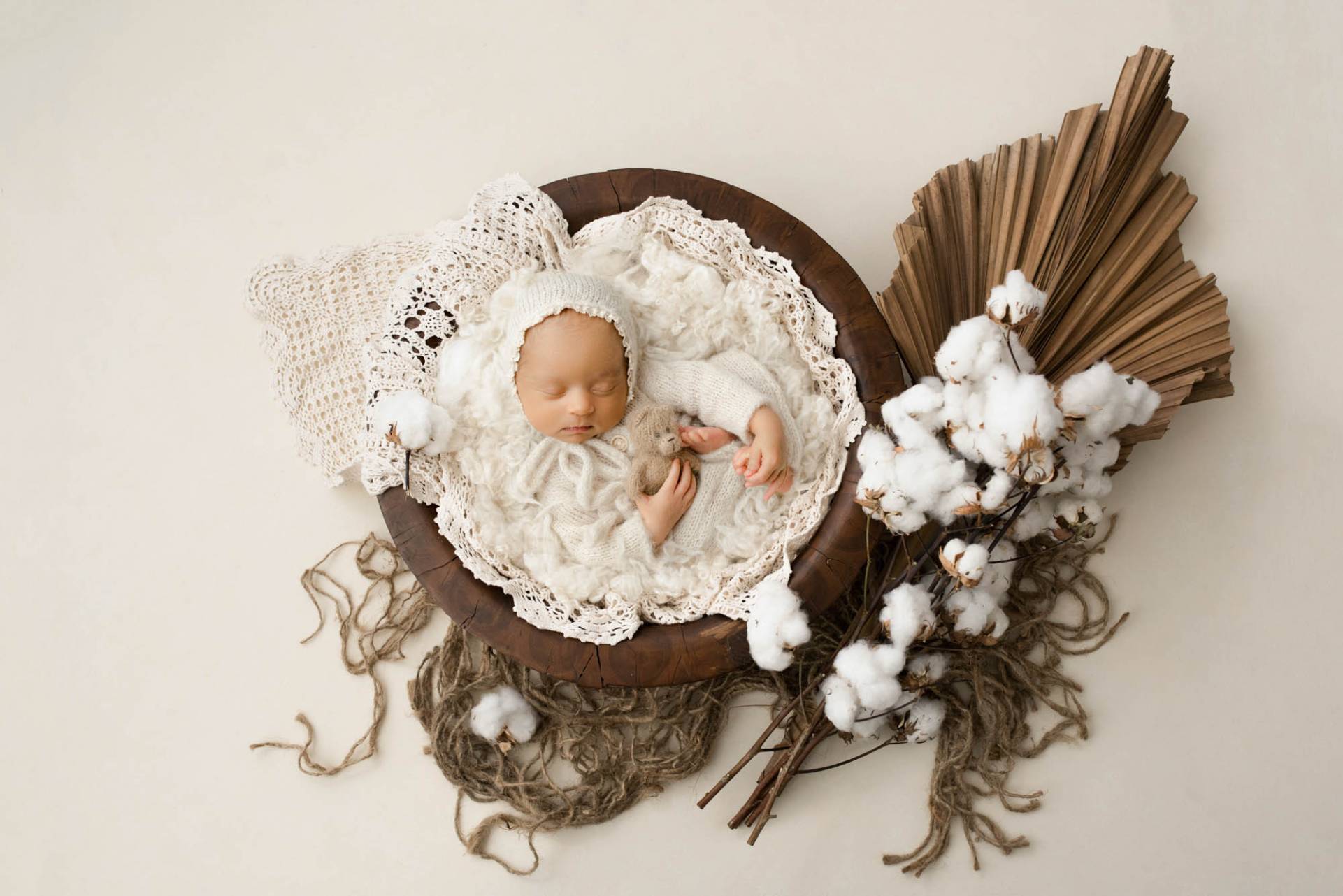 Dallas newborn photographer Lily Hayes Photography captures a peaceful studio newborn portrait featuring a baby wrapped in soft ivory textures with organic cotton and neutral styling.